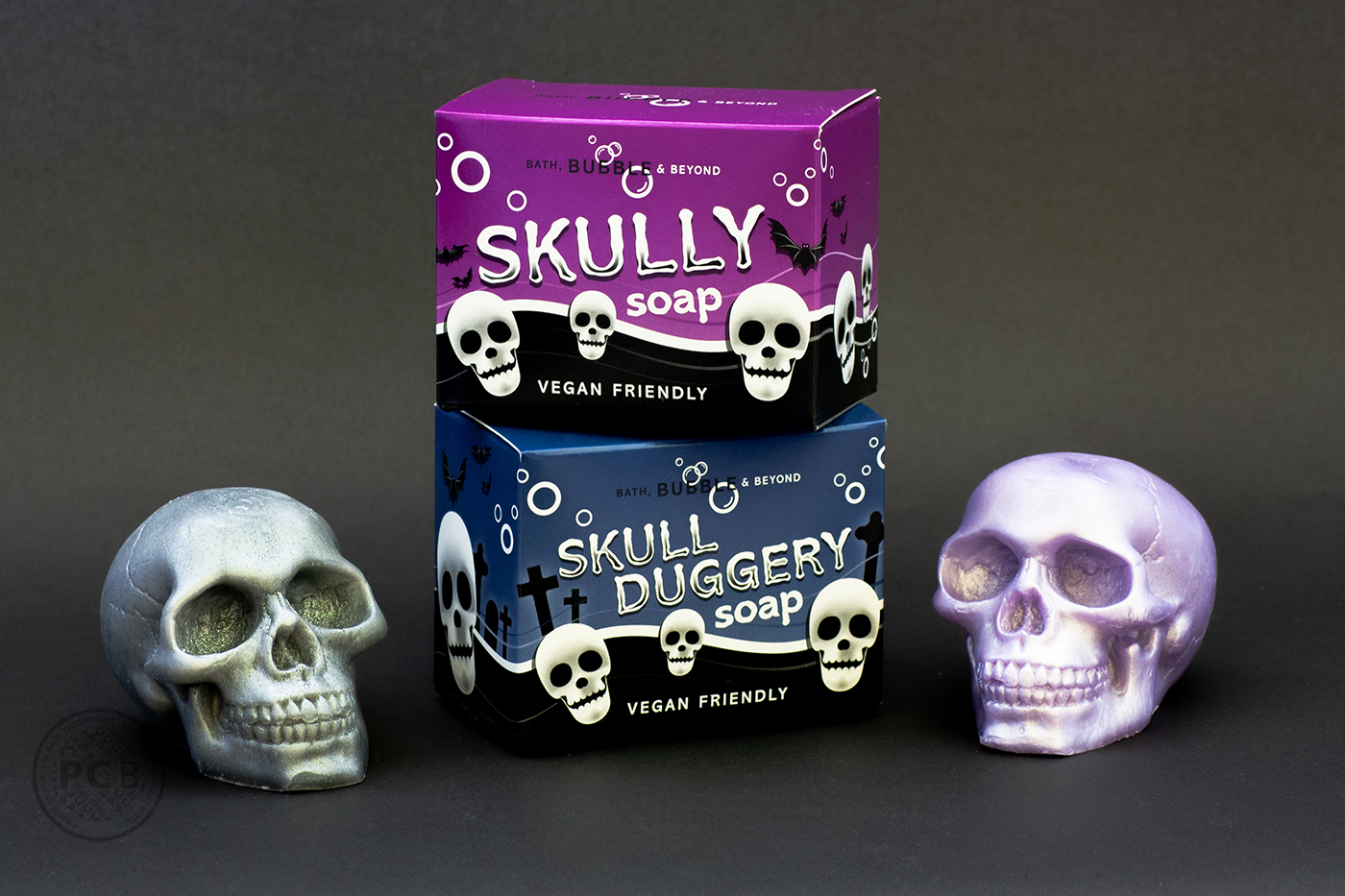 Studio image of two novelty soap cartons and two skull-shaped soaps.