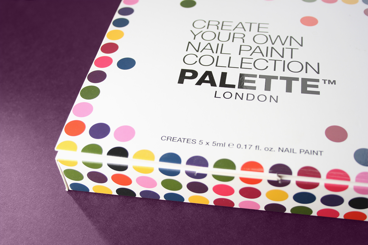 Close-up of box containing nail varnish mixing bottles. Brightly colour dots and bold logo.