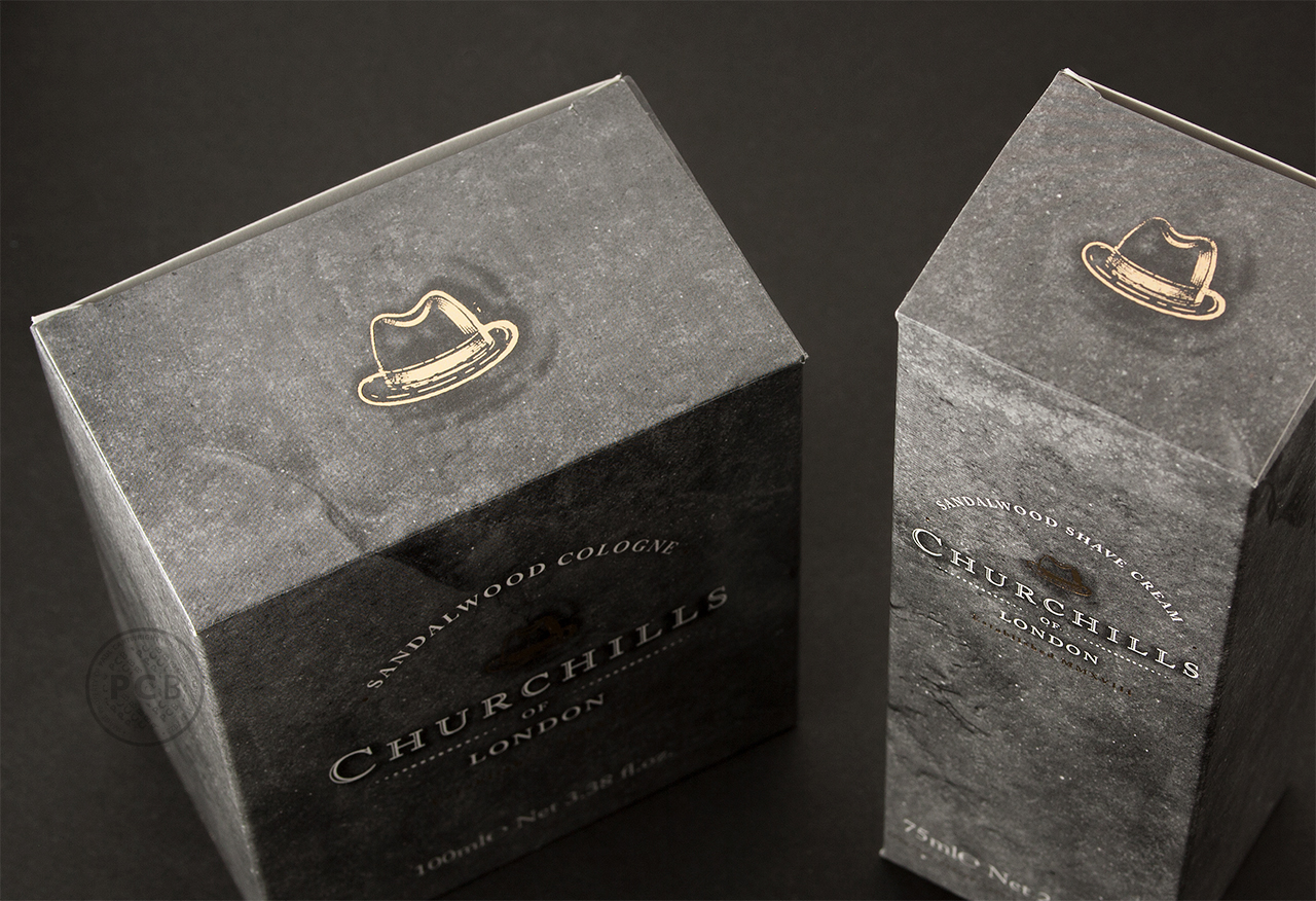 Carton lids featuring metallic foiled homburg hat icon for men's traditional toiletries products.